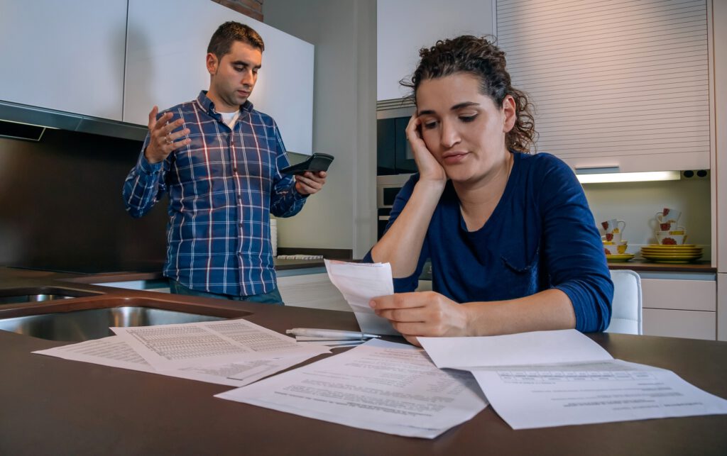 Desperate young couple with debts reviewing their bills