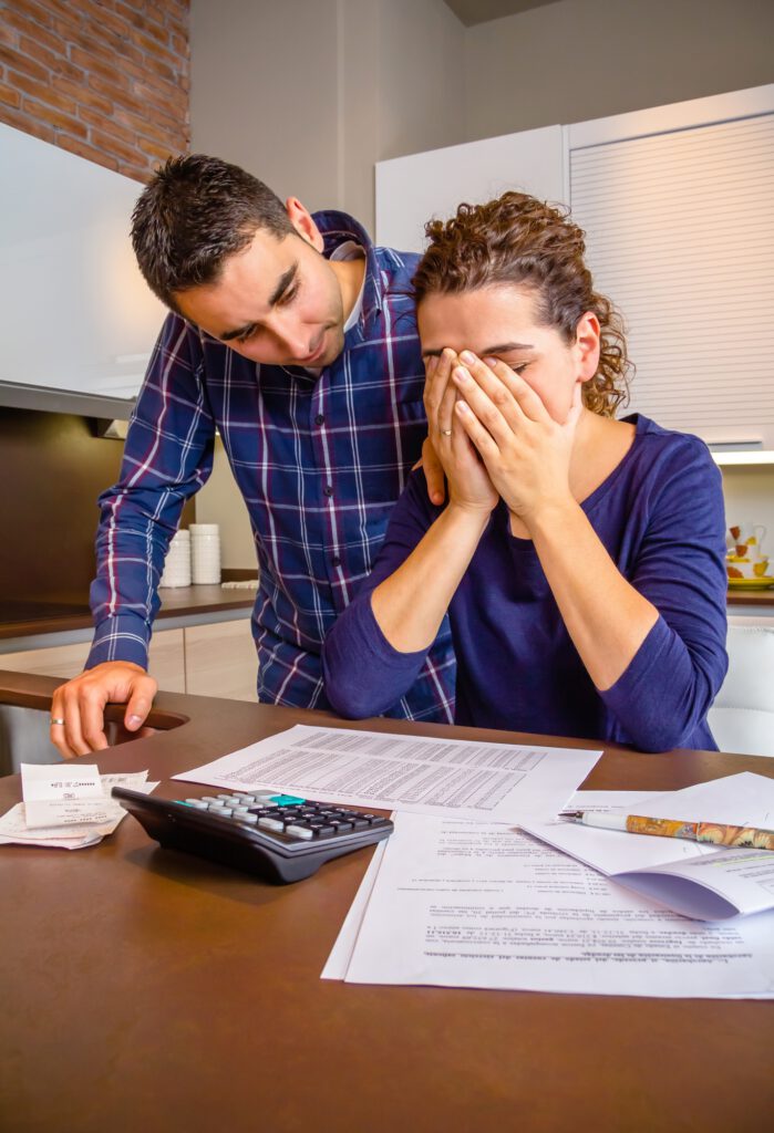 Desperate young woman with debts reviewing the bills